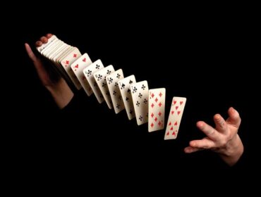 magician showing his trick on black background