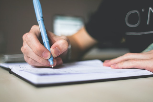 man writing on table