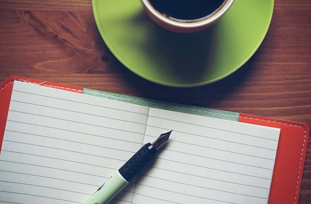 writing materials beside coffee mug on table